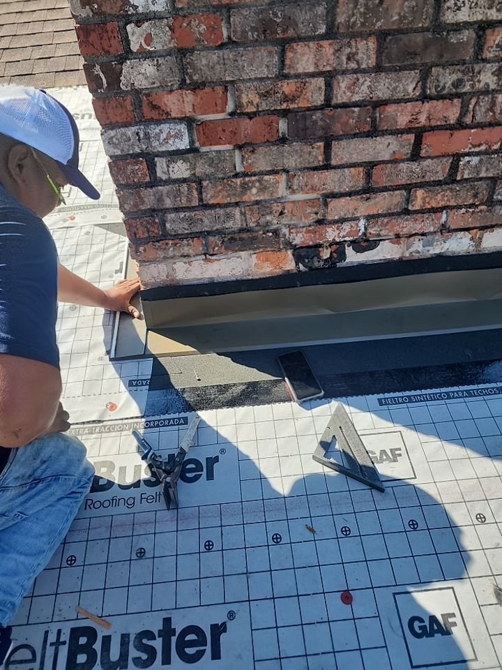 Close-up of chimney flashing detail work on a shingle roof